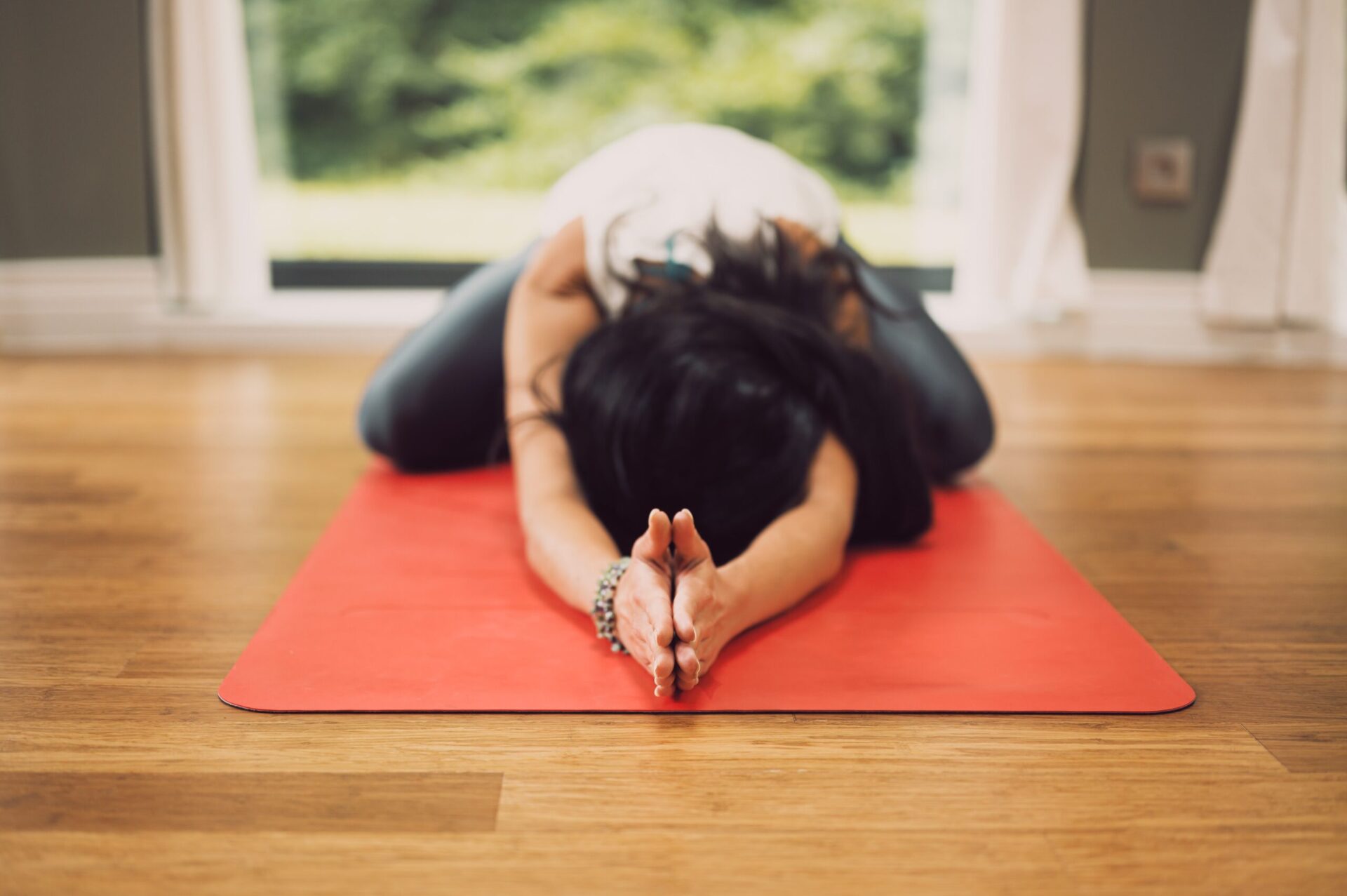 person in yoga pose on red mat