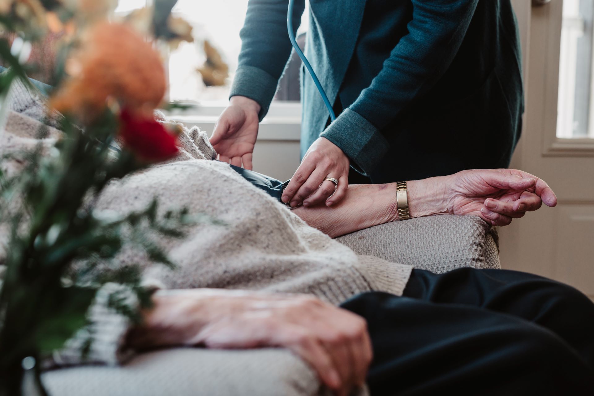 A PRT nurse takes the blood pressure of a hospice patient in their home